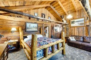 a bedroom in a log cabin with a bed and a couch at Remote Escape Klamath Falls Cabin By Lake and Hikes in Klamath Falls