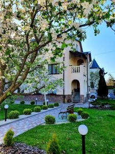 a house with a flowering tree in front of it at Villa ZENKO in Lviv
