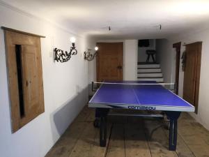 a ping pong table in a room with a staircase at Posta Veglia in Sils Baselgia