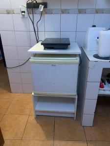 a small white refrigerator with a laptop on top of it at Cassanova III in San Luis