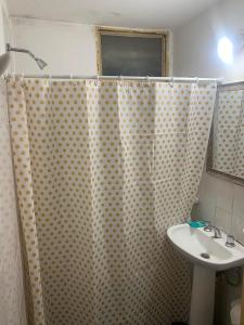 a bathroom with a shower curtain and a sink at Cassanova III in San Luis +2 photos