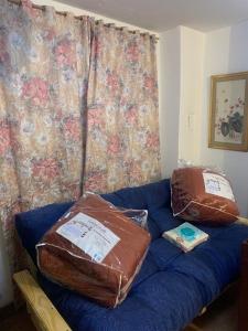 a blue couch with two pillows on top of it at Cassanova III in San Luis