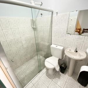 a bathroom with a shower and a toilet and a sink at Pousada Vila do Penedo in Penedo +20 photos