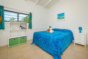 a bedroom with a bed and a dresser and a window at Aroa Beachside Resort in Rarotonga