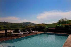 una piscina con sillas y vistas a las montañas en Relais B&B Betty Bike en Sassofeltrio