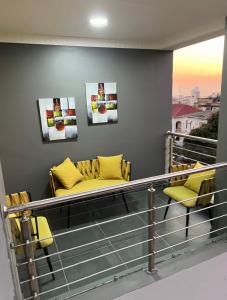 a balcony with two yellow chairs and a couch at INCANTO RESIDENCIAL in Maputo