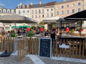 a restaurant with tables and umbrellas in a city at Disneyland Paris, vallée village ,Paris , villa, garden , Syline Home, 120 m2 in Serris