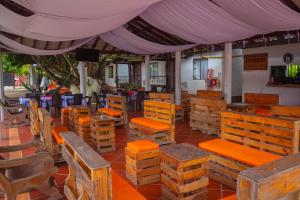 un restaurante con mesas y sillas de madera y una tienda de campaña en Cabañas El Samán Villavicencio, en Villavicencio