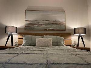 1 dormitorio con 1 cama grande y 2 lámparas en Modern luxurious unit in the heart of Dickson en Canberra