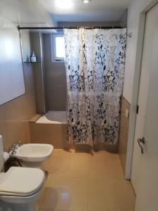 a bathroom with a toilet and a shower curtain at MI CASA TU CASA in El Calafate