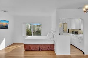 ハリウッドにあるSilver Spray Motelの白いベッドルーム(ベッド1台、シンク付)