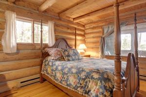 una camera con un letto in una baita di tronchi di Lakefront Fence Home with Private Hot Tub! 