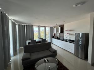 a living room with a couch and a kitchen at Suites Rubí - Las Mejores vistas de San Carlos in San Carlos