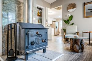 una stufa a legna in un soggiorno con tavolo di Cozy & Modern w Hot Tub, Fire Pit, Grill & Pond a Morton Grove