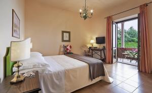ein Schlafzimmer mit einem Bett und einem Tisch mit einer Lampe in der Unterkunft Hotel Villa Sirina in Taormina + 37 Fotos