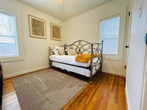 a bedroom with a bed and two windows at Home Sweet Idahome, feels like home with all the decor you wish you could afford King bed in master, fully fenced dog friendly yard, a few blocks from BSU and downtown Boise, Your perfect stay! in Boise