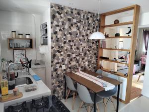 uma cozinha e sala de jantar com uma mesa e um lavatório em Quarto de solteiro/casais em Teresópolis