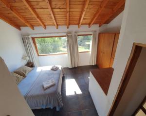 Habitación pequeña con cama y ventana en Casa Catedral Bariloche en San Carlos de Bariloche