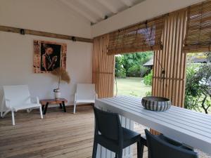 a dining room with a white table and chairs at Green Villa Moorea in Temae