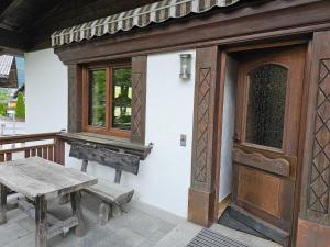 eine Veranda mit einer Holztür und einer Holzbank in der Unterkunft Ferienwohnung Singer in Völs