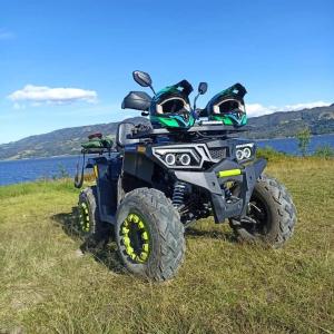 a atv parked in the grass next to a lake at Glamping La Cacica in Guatavita