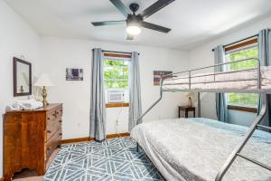 - une chambre avec des lits superposés et un ventilateur de plafond dans l'établissement Hot Tub, Fire Pit, Screened Porch at Secluded Cabin, à Great Cacapon