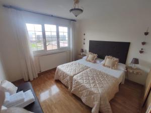1 dormitorio con cama y ventana grande en KANPONDOA ETXEA, en Aoiz
