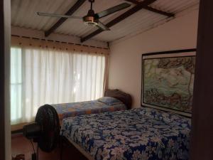 a bedroom with two beds and a ceiling fan at Cabaña en la playa Punta Bolivar in San Antero