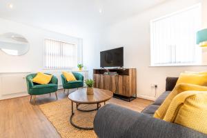 uma sala de estar com um sofá e cadeiras e uma televisão em Home from Home - 5 mins from town! em Liverpool