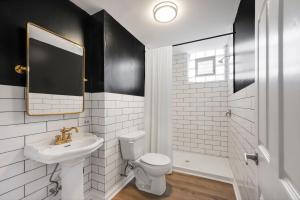 uma casa de banho com um lavatório, um WC e um espelho. em Randolph Hotel em Fox Lake