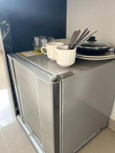 a counter with plates and utensils on top of a refrigerator at Hotel boutique bussines center in Cali