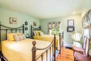 two beds in a bedroom with green walls at Enchanting Cottage, walk to Downtown Harpers Ferry in Harpers Ferry