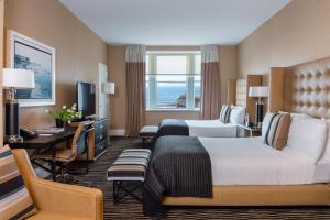 a hotel room with two beds and a desk at Berkeley Oceanfront Hotel in Asbury Park