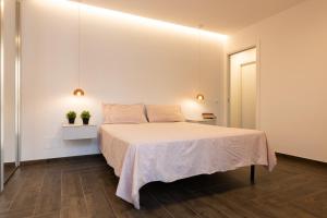 ein Schlafzimmer mit einem Bett und einer weißen Wand in der Unterkunft Rosina Apartment surfing bed&vacation in Terrasini