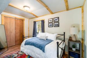 - une chambre avec un lit et une couverture bleue dans l'établissement Hot Tub, Huge Deck, Lake, & FirePit at Cozy Cabin, à Lost City