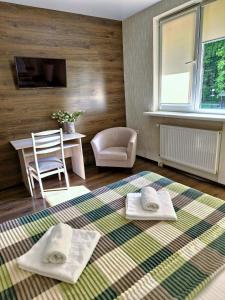 een kamer met een tafel en twee handdoeken op een tapijt bij Villa ZENKO in Lviv