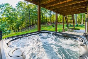 a hot tub in the backyard of a house at Large Cabin w Hot Tub, Pond, Deck, Fire Pit, WiFi in Morton Grove