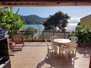 阿拉薩奇巴海灘的住宿－Lopes House Araçatiba，阳台配有桌椅,享有水景