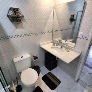 a bathroom with a toilet and a sink and a mirror at Lopes House Araçatiba in Praia de Araçatiba