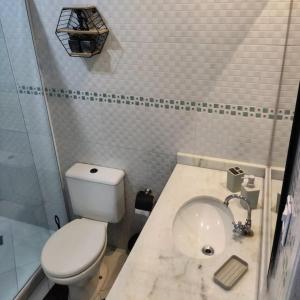 a bathroom with a white toilet and a sink at Lopes House Araçatiba in Praia de Araçatiba