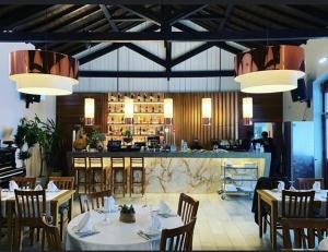 um restaurante com mesas e cadeiras e um bar em Salero Guest House em Loures