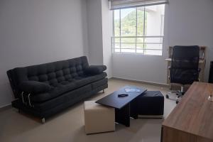 ein Wohnzimmer mit einem Sofa und einem Couchtisch in der Unterkunft Alojamiento Vacacional en San Gil in San Gil
