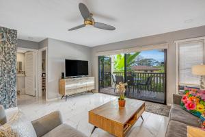 a living room with a couch and a tv at Waikomo Stream Villas 322 in Koloa
