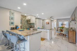 a kitchen with white cabinets and a table and chairs at Waikomo Stream Villas 322 in Koloa