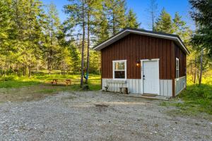 una piccola cabina con una porta bianca e una panchina di Little Tooth Retreat - Little Cabin a Sandpoint