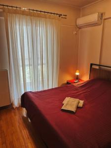 - une chambre avec un lit rouge et 2 serviettes dans l'établissement Glyfada Prime Location Spacious Apartment, à Athènes