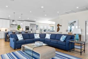 a living room with a blue couch and a kitchen at Poseidon in Atlantic Beach