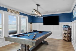 a pool table in a room with a tv at Poseidon in Atlantic Beach