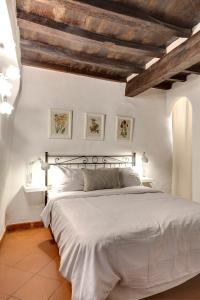a bedroom with a large white bed with wooden ceilings at Florence Holiday Homes Santa Maria Novella in Florence