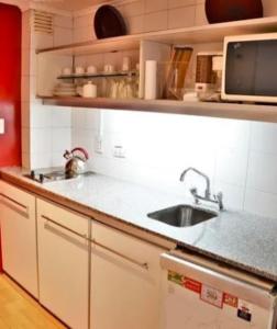 a kitchen with a sink and a microwave at Corrientes y Riobamba in Buenos Aires